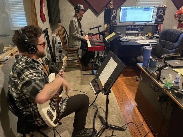 Bass player and keyboard player tracking together in the control room