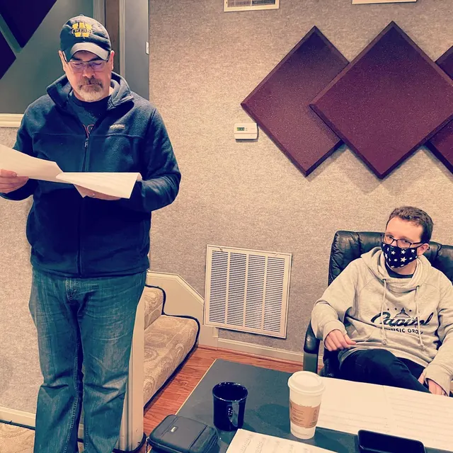 Two musicians going over charts during a session