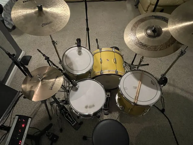 Overhead view of the yellow house drum kit and cymbals