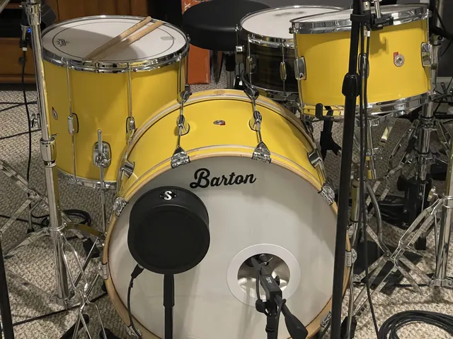 Close-up of the yellow house drum kit with microphones in the drum room