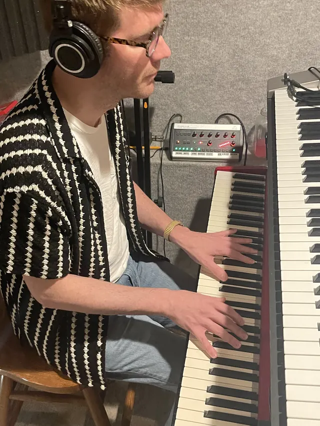 Keyboard player with a headset mic playing a stage piano