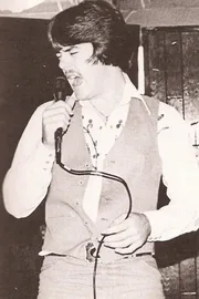 Vintage sepia photo of a young Terry singing into a microphone on stage